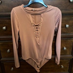 Mauve colored lace up body suit. Never worn; tags were ripped off.